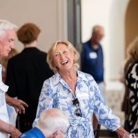 Woman with blond hair smiling and looking at gentleman standing next to here